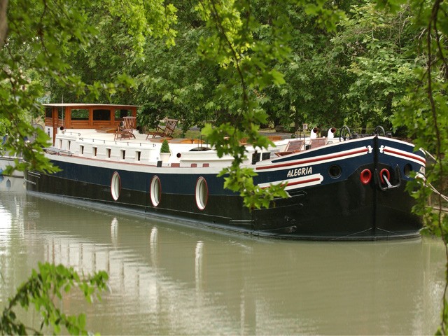 The four-passenger deluxe hotel barge Alegria cruises on the historic 300-year-old Canal du Midi.