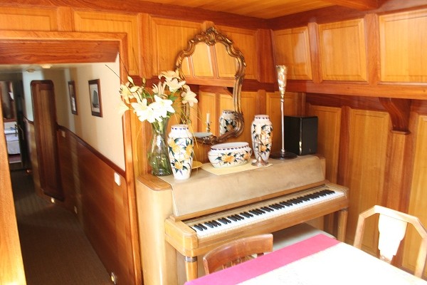 The salon with piano, looking toward the hallway with the Van Gogh, Cezanne and Renoir cabins aboard the Tango.
