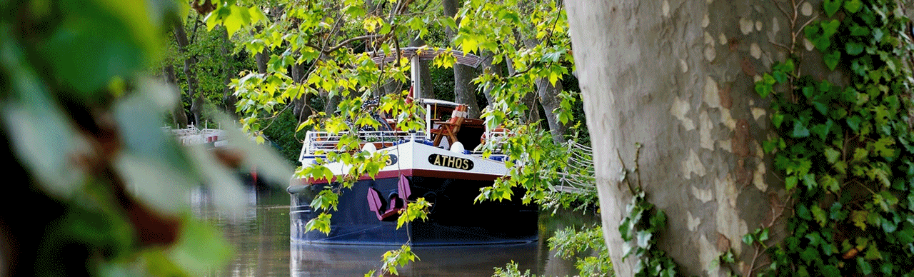 Barge Cruises In France and Europe. Pictured here is the ATHOS cruising on the Canal du Midi; the deck of the LILAS cruising in Burgundy; the salon of LA NOUVELLE ETOILE cruising in Holland, France, and Germany; the dining table of SPIRIT OF SCOTLAND cruising Loch Ness area in Scotland; and a cabin aboard PIVOINE cruising in Champagne