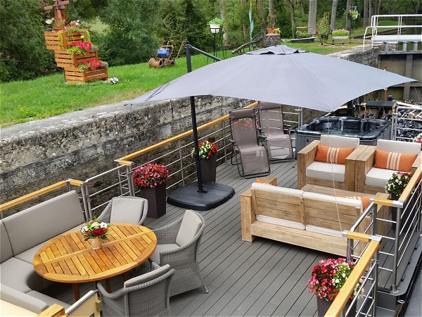 The comfortable and spacious deck aboard the Rendez-Vous
as the barge negotiates<br>a lock on the Canal de Bourgogne.