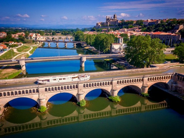 Roi Soleil crossing the canal bridge
with hilltop views of Beziers