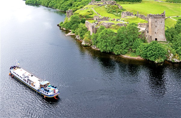 Scottish
Highlander cruising on Loch Ness past Urquhart Castle